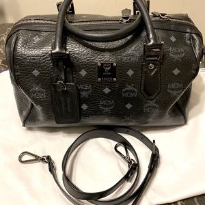 It’s a mcm women’s bag .it’s black with grey snake skin